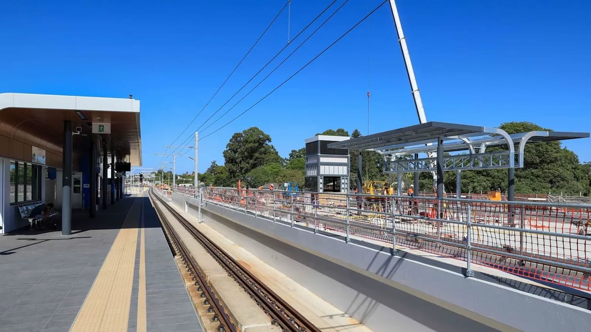 New elevated rail station platform and canopy under construction beside the running lines
